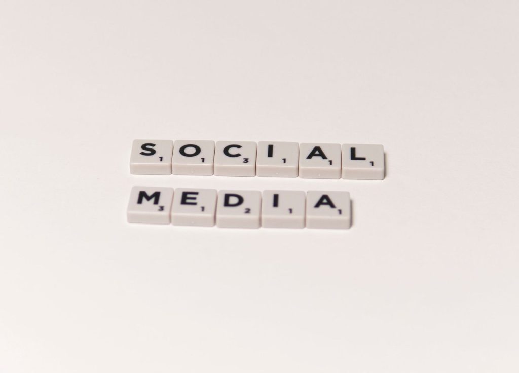 Peças de jogo de palavras formam a expressão “social media” sobre um fundo branco.